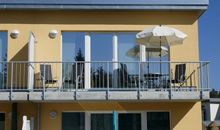 Südbalkon mit Sitzmöbeln und Sonnenschirm