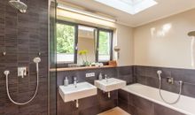 Badzimmer mit Badewanne und bogengleicher Dusche
