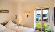 Das helle Schlafzimmer mit Boxspringbett (1,80 m x 2,00 m) und Fernseher