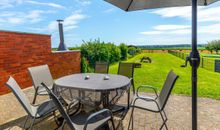 Terrasse mit Gartenmöbeln und Sonnenschirm