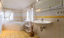 Badezimmer mit Badewanne und Dusche