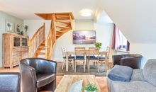 Wohnzimmer mit offener Küche, Essplatz und Treppe zum Obergeschoss