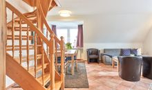 Wohnzimmer mit Sitzecke und Zugang zum Balkon