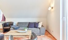 Wohnzimmer mit Sitzecke und Zugang zum Balkon