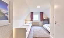 Schlafzimmer 2 mit drei Einzelbetten und begehbarem Schrank