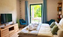 offenes Wohn-/Schlafzimmer mit einem bequemen Doppelbett in Komforthöhe