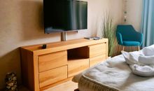 offenes Wohn-/Schlafzimmer mit einem bequemen Doppelbett in Komforthöhe