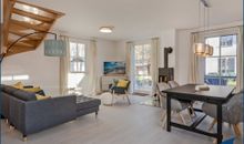 Wohn7Esszimmer mit Kamin und offener Küche