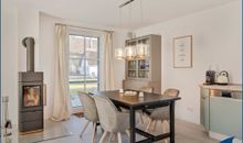 Wohn-/Esszimmer mit Kamin und offener Küche