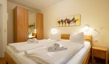 Das erste Schlafzimmer mit Doppelbett und Kleiderschrank