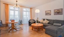 Wohnzimmer mit offener Küche und Zugang zum Balkon