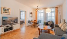 Wohnzimmer mit offener Küche und Zugang zum Balkon