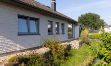 Ferienhaus Seitenansicht, daneben ein kleiner Bachlauf