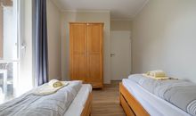 Das zweite Schlafzimmer mit zwei Einzelbetten und einem Kleiderschrank