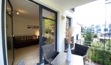 bestuhlter Balkon mit Blick ins Wohnzimmer