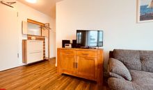 Wohnzimmer mit offener Küche und Zugang zum Balkon
