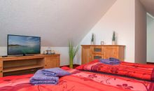 Das erste Schlafzimmer im DG mit zwei Einzelbetten und Flachbild-TV