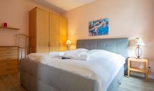 Das Schlafzimmer mit Doppelbett und Kleiderschrank