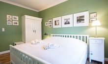 Das erste Schlafzimmer mit Doppelbett und Kleiderschrank