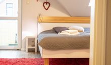 Blick ins Schlafzimmer mit Zugang zum Balkon