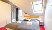 Das Schlafzimmer mit Doppelbett und großem Kleiderschrank
