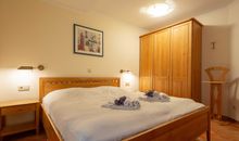Das Schlafzimmer mit Doppelbett und großem Kleiderschrank