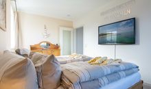 Das erste Schlafzimmer mit Doppelbett und Flachbild-TV