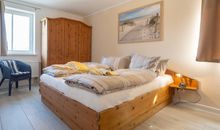 Das erste Schlafzimmer mit Doppelbett und Kleiderschrank