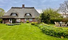 Garten mit Blick auf das große Reetdachhaus