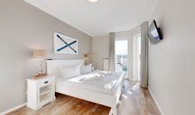 Schlafzimmer mit Doppelbett und TV