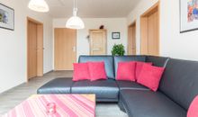 Wohnbereich mit schwarzem Lederecksofa