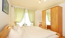Schlafzimmer mit Doppelbett und Kleiderschrank